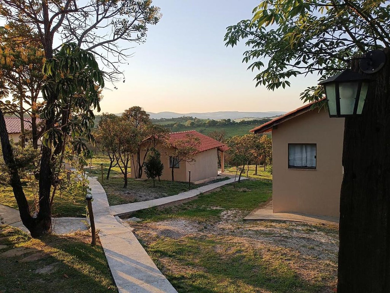 Caminho entre os chalés ao entardecer, com a serra ao fundo
